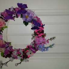 Wreath decorated with artificial flowers and butterflies