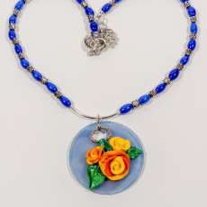 Hand sculpted multi-colored clay roses on polymer disk necklace