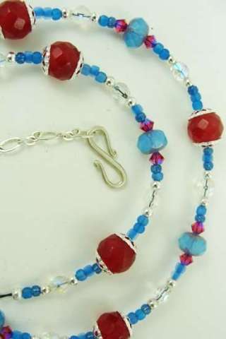 Maroon gemstones with blue faceted glass and crystal necklace.