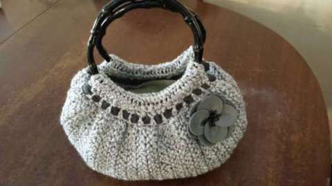 Very cute, grey crocheted handbag.