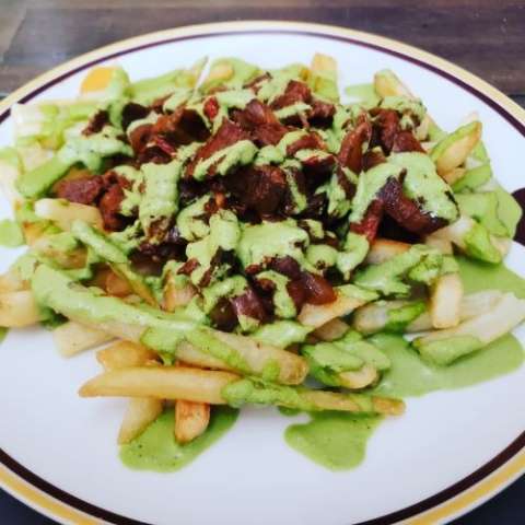 Beef Lomo Saltado With French Fries and Aji Verde Sauce.