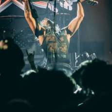 Chase Raising His Guitar to the Rock Heavens