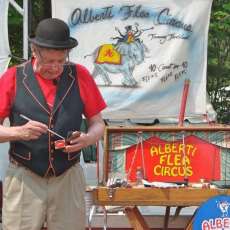 Close up of Alberti bringing Merlin out of his trunk