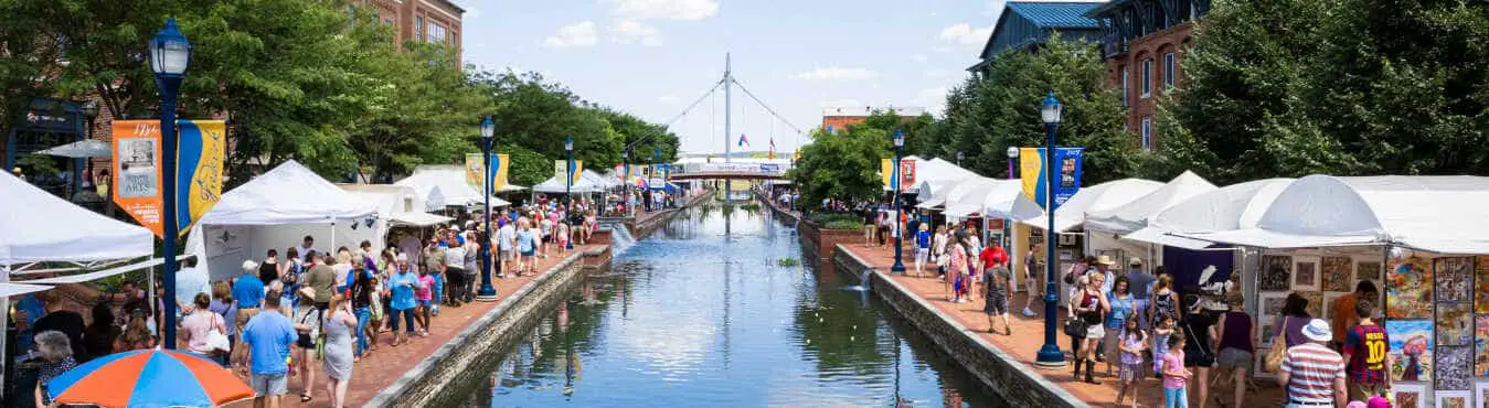 People gather on the walkway at Frederick Maryland's Linear Creek to celebrate the annual Festival of the Arts.