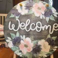 round wooden welcome sign